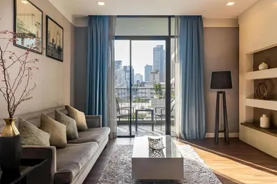 a living room with a couch and a large window at Metropolis Suites Bangkok, Tapestry Collection by Hilton in Bangkok