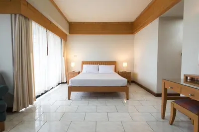 a bedroom with a bed and a large window at Baan Pratoom in Bangkok