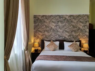 a bedroom with a bed with a large headboard at Praya Palazzo in Bangkok