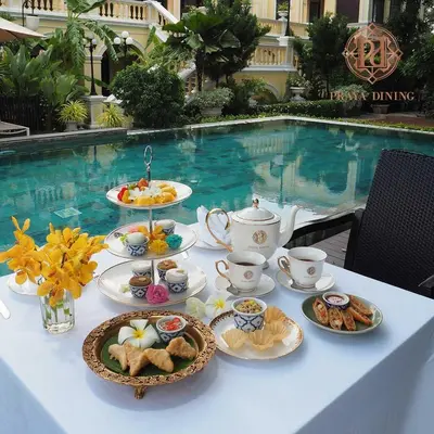 a table with cups and plates of food on it at Praya Palazzo in Bangkok
