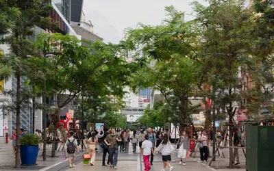 a crowd of people walking down a city street at Lub d Bangkok Siam - New Look, Across from MBK & Skytrain Access in Bangkok