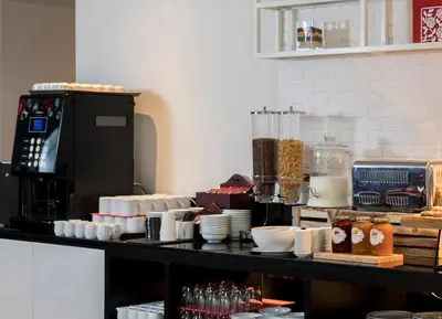 a counter with plates and bowls on a table at Travelodge Sukhumvit 11 in Bangkok