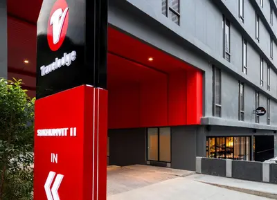 a building with a red sign in front of it at Travelodge Sukhumvit 11 in Bangkok