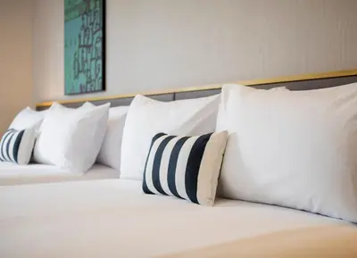 a bed with white pillows on top of it at Travelodge Sukhumvit 11 in Bangkok