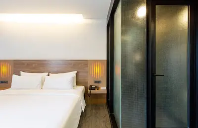 a bedroom with a large bed and a glass shower at STAY Hotel BKK in Bangkok
