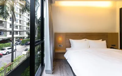 a bedroom with a bed and a large window at STAY Hotel BKK in Bangkok