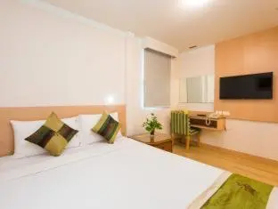 a bedroom with a large white bed and a television at Wall Street Inn, Bangkok in Bangkok