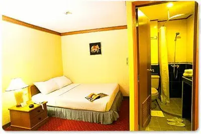 a hotel room with a bed and a bathroom at Wall Street Inn, Bangkok in Bangkok