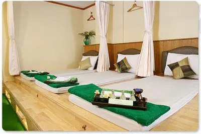 two beds in a room with green and white at Wall Street Inn, Bangkok in Bangkok