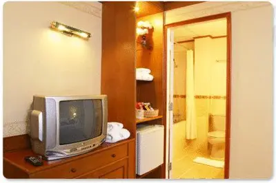 a television sitting on a dresser in a bathroom at Wall Street Inn, Bangkok in Bangkok