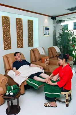 a man and a woman sitting on a chair in a room at Wall Street Inn, Bangkok in Bangkok