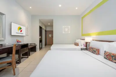 a hotel room with two beds and a desk at Hotel De Bangkok in Bangkok