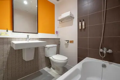 a bathroom with a toilet and a sink and a tub at Hotel De Bangkok in Bangkok