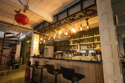 a bar in a restaurant with chairs at River View Residence in Bangkok
