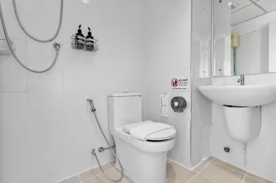 a white bathroom with a toilet and a sink at River View Residence in Bangkok