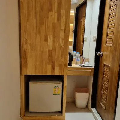 a bathroom with a sink and a wooden cabinet at Cozi Inn Hotel, Bangkok in Bangkok