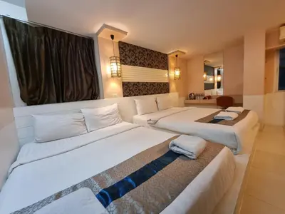 a hotel room with two beds in a room at Cozi Inn Hotel, Bangkok in Bangkok