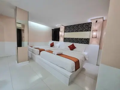 a white bedroom with a large bed in it at Cozi Inn Hotel, Bangkok in Bangkok