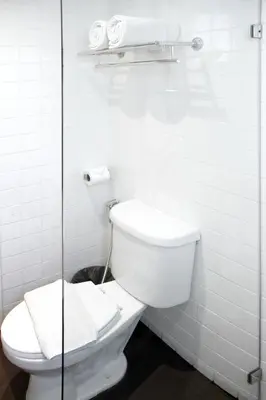 a bathroom with a toilet and a glass shower at My Hotel Pratunam in Bangkok