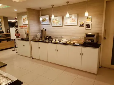a kitchen with white cabinets and a counter top at My Hotel Pratunam in Bangkok