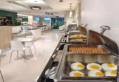 a buffet line with eggs and other breakfast foods at My Hotel Pratunam in Bangkok