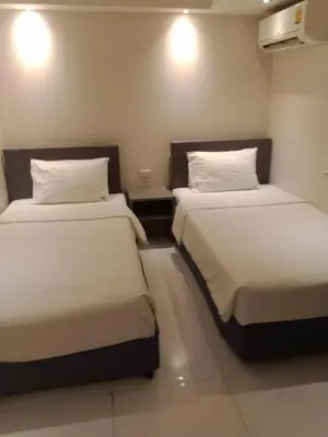 two beds in a small room with two beds sidx sidx sidx at My Hotel Pratunam in Bangkok