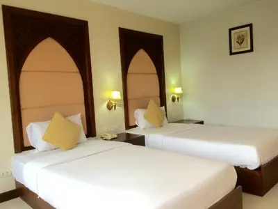 two beds in a hotel room with white sheets at For You Residence in Bangkok