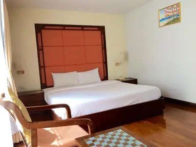 a bedroom with a large white bed and a chair at For You Residence in Bangkok