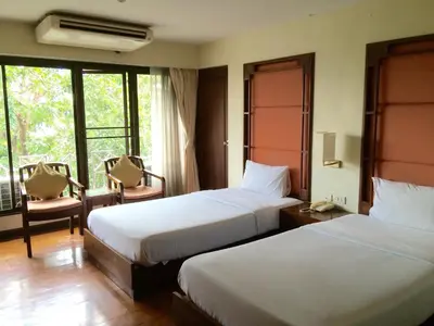 a hotel room with two beds and a window at For You Residence in Bangkok
