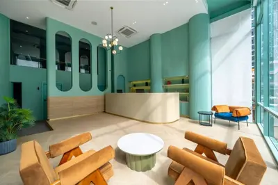 a lobby with green walls and a table and chairs at Myhotel Cmyk@Ratchada in Bangkok