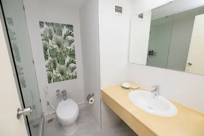 a bathroom with a toilet and a sink and a mirror at MIDO Hotel in Bangkok