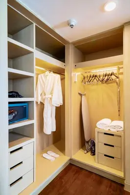 a walk in closet with white clothes and a sink at Shama Petchburi 47 Bangkok in Bangkok