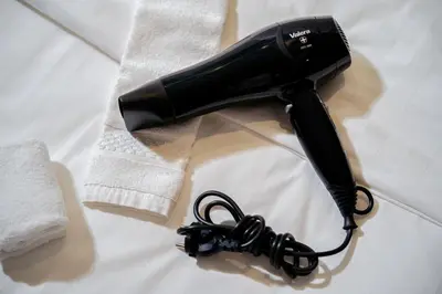 a hair dryer sitting on a table with a towel at Shama Petchburi 47 Bangkok in Bangkok