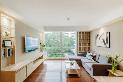 a living room with a couch and a tv at Shama Petchburi 47 Bangkok in Bangkok