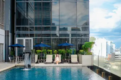a woman in a dress sitting in a pool on a building at Four Points by Sheraton Bangkok Ploenchit Sukhumvit in Bangkok