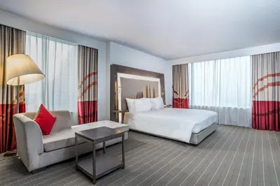 a hotel room with a bed and a chair at Four Points by Sheraton Bangkok Ploenchit Sukhumvit in Bangkok