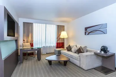 a living room with a couch and a flat screen tv at Four Points by Sheraton Bangkok Ploenchit Sukhumvit in Bangkok
