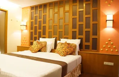 a bedroom with a bed with white sheets and pillows at Golden House in Bangkok
