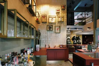 a restaurant with a bar with glasses on the wall at Golden House in Bangkok