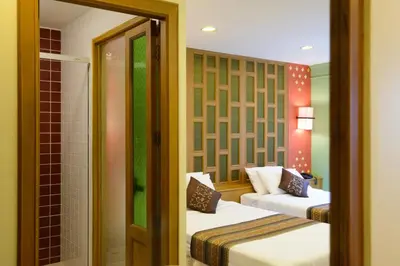 a hotel room with two beds and a shower at Golden House in Bangkok