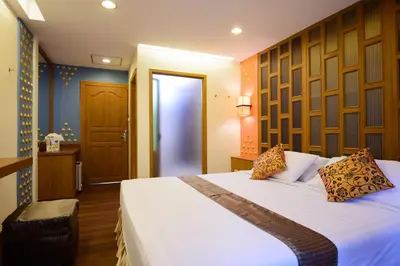 a bedroom with a large bed with white sheets at Golden House in Bangkok
