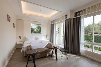 a bedroom with a bed and a large window at Siam Tharadol in Bangkok