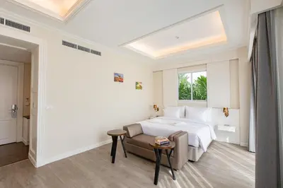 a white bedroom with a bed and a couch at Siam Tharadol in Bangkok
