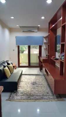 a living room with a couch and a large window at The Supara in Bangkok