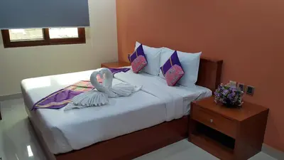 a bedroom with a bed with pillows and a table at The Supara in Bangkok