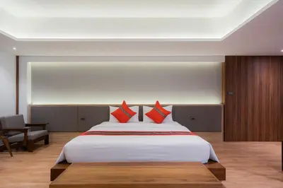 a bedroom with a large white bed with red pillows at True Siam Phayathai Hotel in Bangkok