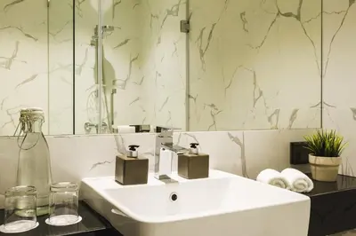 a bathroom with a white sink and a mirror at ZAZZ Urban Bangkok in Bangkok