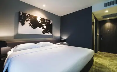 a bedroom with a large white bed and a map on the wall at ZAZZ Urban Bangkok in Bangkok