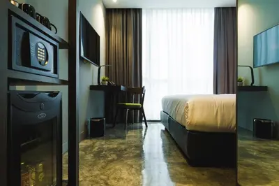 a hotel room with a bed and a desk and a television at ZAZZ Urban Bangkok in Bangkok