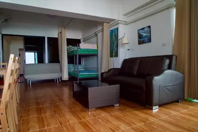 a living room with a couch and a bed at SKB Mansion close to MRT in Hua mark in Bangkok